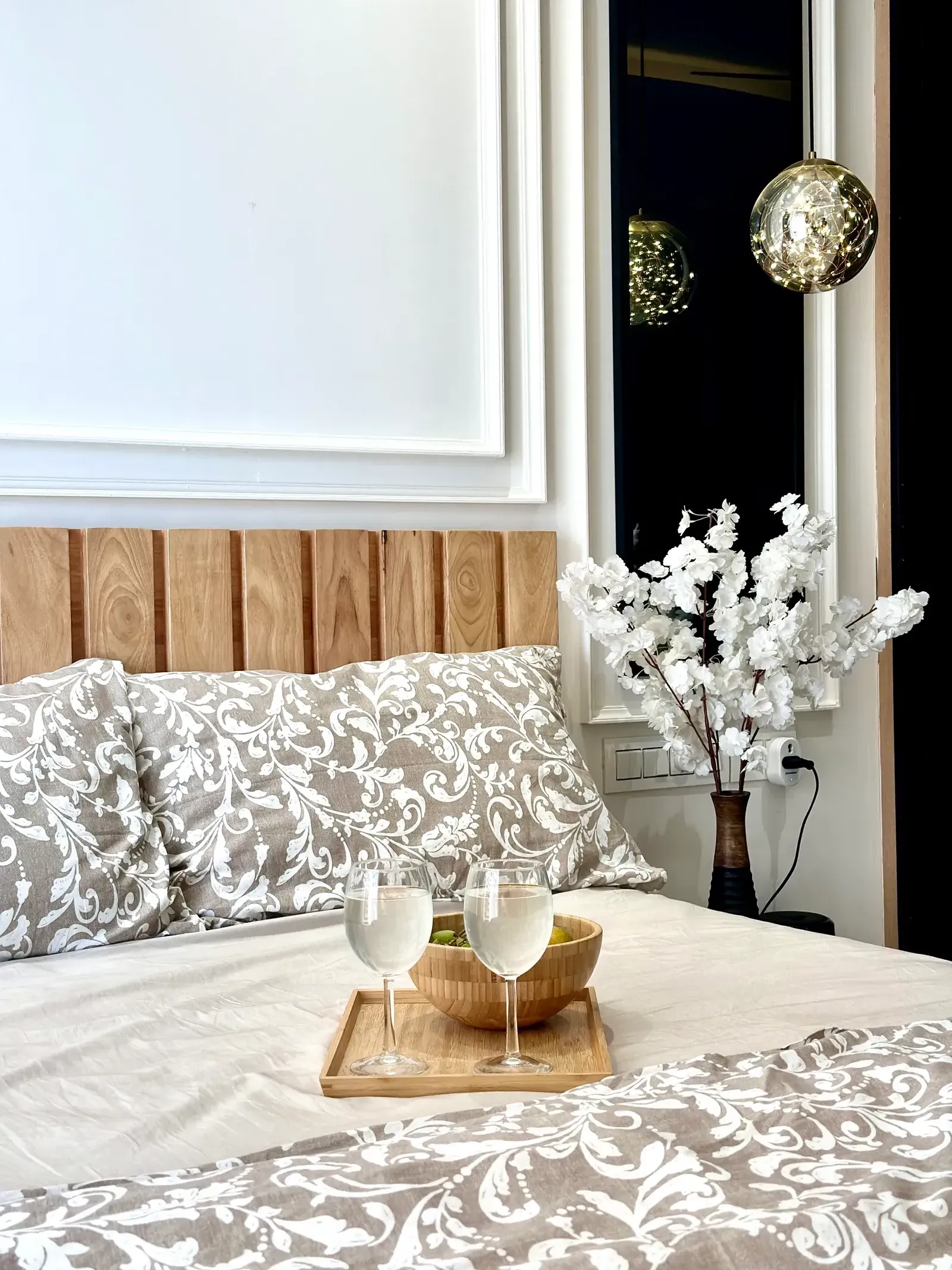 Bed styled with breakfast tray and floral arrangement — The Aakar